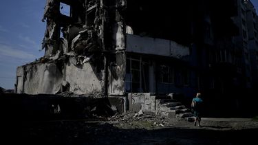 Una mujer camina junto a un edificio destruido por los bombardeos rusos en Borodyanka, en las afueras de Kiev, Ucrania, el martes 21 de junio de 2022.&nbsp;