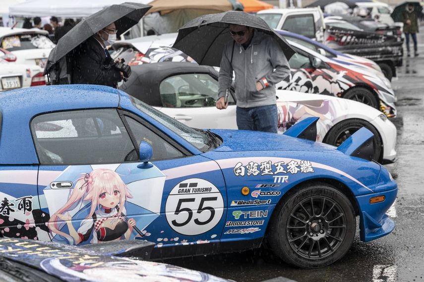Esta foto tomada el 26 de marzo de 2023 muestra a los visitantes mirando los autos alineados durante el festival Odaiba Itasha Heaven 2023 (Itasha Tengoku), donde se exhiben autos decorados con varias imágenes y personajes de anima y manga, conocidos como itasha. en Tokio, Japón.