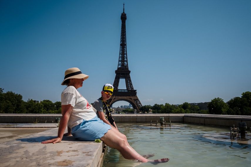 Los turistas se refrescan en la Fuente del Trocadero, frente a la Torre Eiffel en París, el 1 de julio de 2025, mientras se espera que las temperaturas en Francia alcancen un pico hoy, según la agencia meteorológica Meteo France, y en algunas áreas se espera que superen los 40 grados Celsius (104 grados Fahrenheit).