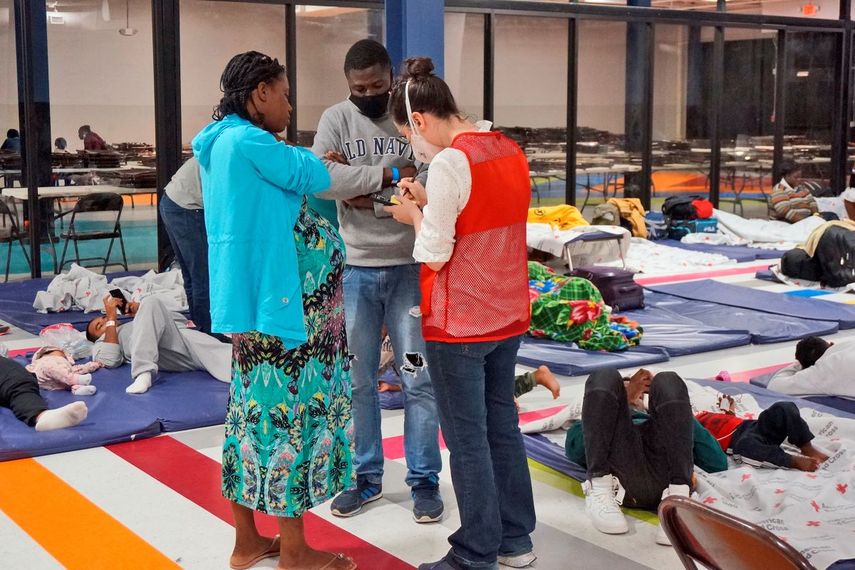 Una voluntaria ayuda a una mujer embarazada y su pareja dentro del Humanitarian Respite Center (Centro de Alivio Humanitario) el jueves 15 de diciembre de 2022