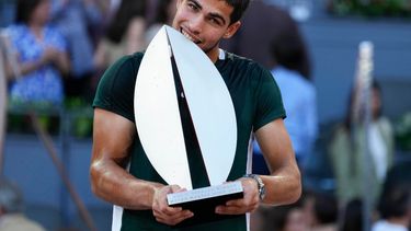 Carlos Alcaraz muerde el trofeo de campeón tras vencer a Alexander Zverev en la final del Abierto de Madrid, el domingo 8 de mayo de 2022.&nbsp;