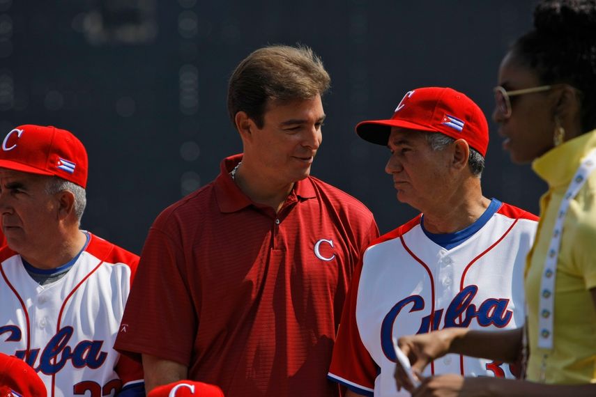 El médico del equipo de Cuba e hijo del dictador cubano Fidel Castro, Antonio Castro, en el centro, habla con el entrenador en jefe Higinio Vélez, a la derecha, mientras se toma una foto del equipo antes de jugar en Sudáfrica durante su juego del Clásico Mundial de Béisbol en la Ciudad de México, el domingo 8 de marzo 2009.