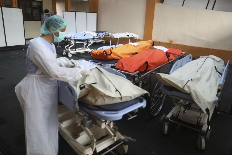Un trabajador médico pone una etiqueta de identificación en los cuerpos de las víctimas de una estampida de fútbol en el Hospital Saiful Anwar en Malang, Java Oriental, Indonesia, el domingo 2 de octubre de 2022. Pánico en un partido de fútbol de Indonesia después de que la policía disparó gases lacrimógenos para Los hinchas dispersos que invadieron la cancha dejaron más de 100 muertos, la mayoría pisoteados, dijo la policía el domingo.