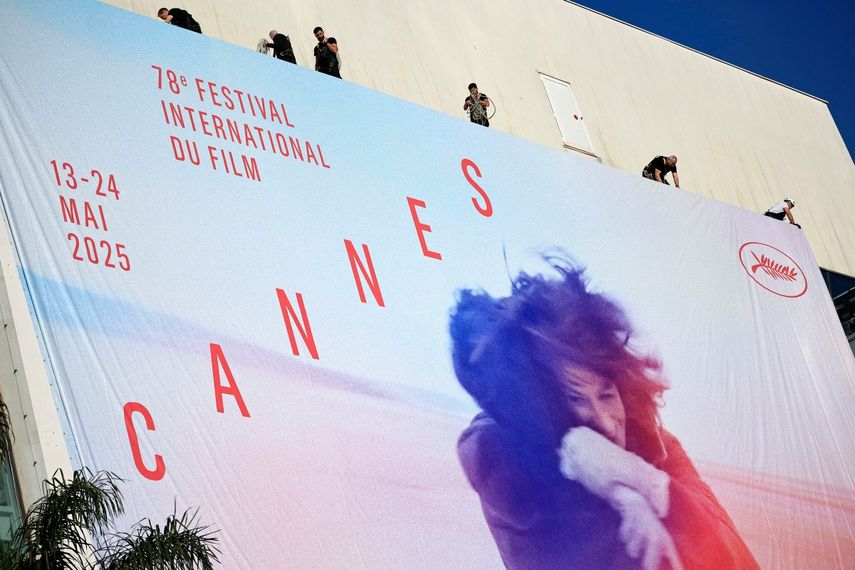 Trabajadores cuelgan el cartel oficial del 78.º Festival de Cine de Cannes en la fachada del Palacio de Festivales de Cannes, sureste de Francia, el 11 de mayo de 2025. El Festival de Cine de Cannes se celebrará del 13 al 24 de mayo.
