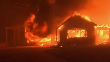 Captura de imagen de un video difundido por la agencia AP de una vivienda envuelta en llamas en el sur de California, el 31 de octubre de 2019.