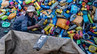 Un joven trabajador afgano clasifica latas de plástico reciclables en un depósito de reciclaje en las afueras de Kabul el 5 de agosto de 2025.