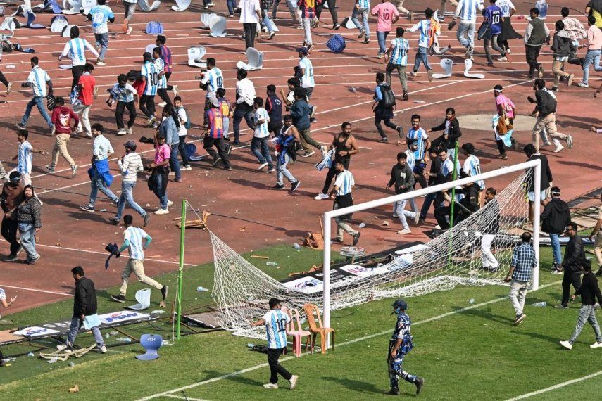 Personal de seguridad intenta controlar a los fanáticos en el Salt Lake Stadium de Calcuta tras la visita de Lionel Messi, el 13 de diciembre de 2025.