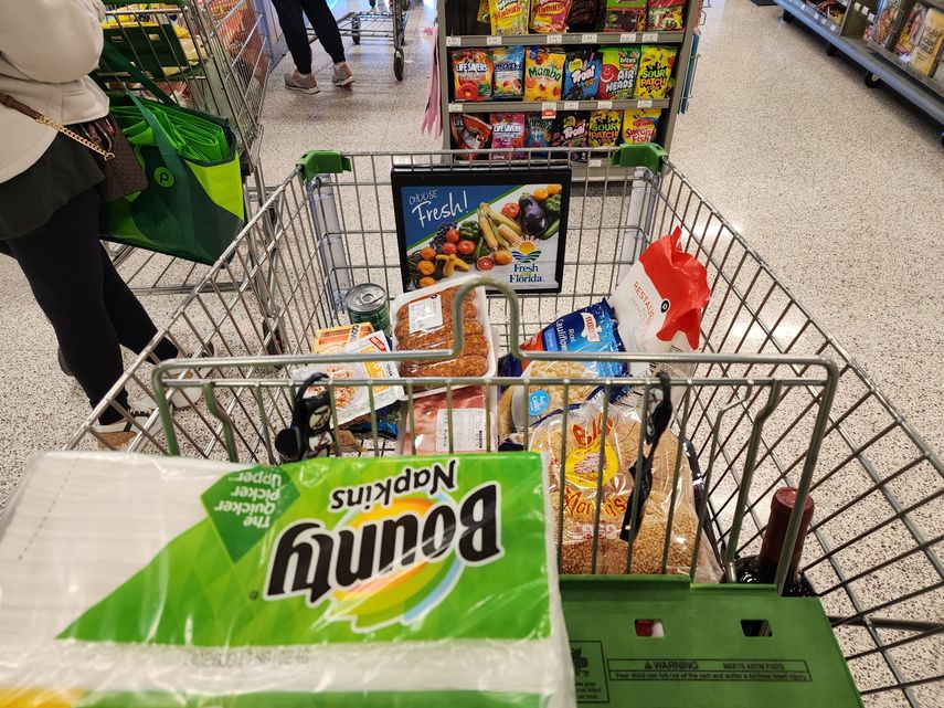 Clientes en fila para pagar sus productos en un mercado de la cadena Publix.