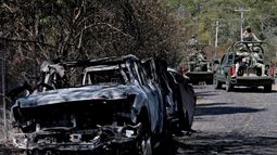 Miembros del ejército a bordo de camiones se ven junto a un automóvil incendiado que se utilizó para bloquear las carreteras mientras el narcotraficante mexicano El Mencho intentaba escapar, cerca del Tapalpa Country Club, donde se escondía en el momento de la operación en la que fue abatido, en Tapalpa, estado de Jalisco, México, el 24 de febrero de 2026.
