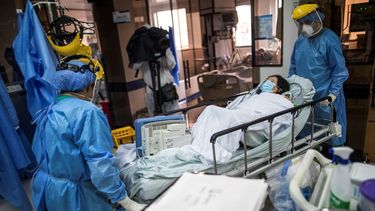 Trabajadores de la salud trasladan a un paciente de COVID-19, dentro de una UCI del Hospital Samaritana en Bogotá, Colombia.