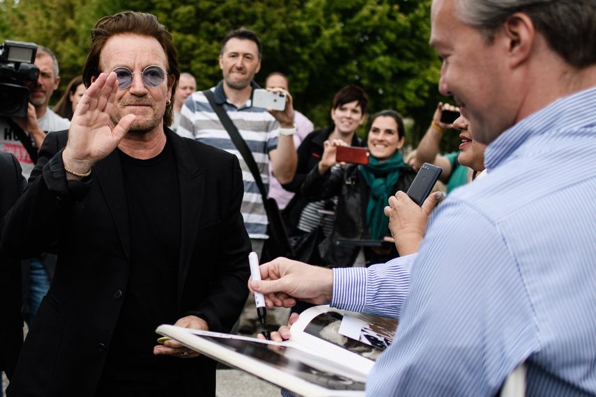 El líder de la bada de rock irlandesa U2, Bono, saluda a sus fans tras reunirse con la canciller alemana, Angela Merkel.&nbsp;
