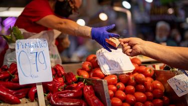 Un cliente paga por verduras en el Mercado de Maravillas de Madrid, el jueves 12 de mayo de 2022.