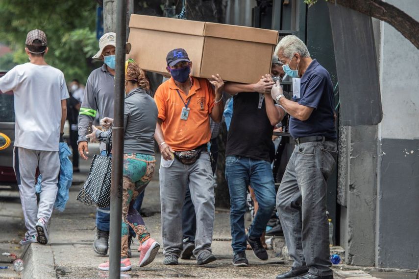 Trabajadores cargan los restos de una persona en un ata&uacute;d de cart&oacute;n en el Cementerio General en Guayaquil, Ecuador, el lune s 6 de abril de 2020.&nbsp;
