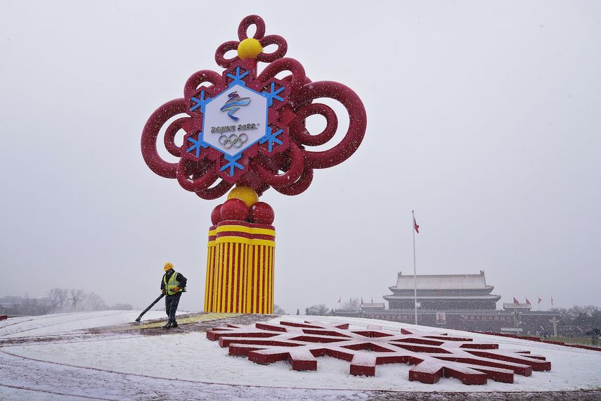 Un trabajador utiliza maquinaria para retirar la nieve de un adorno alusivo a los Juegos Olímpicos de Invierno, en la Plaza de Tiananmen en Beijing, el 20 de enero de 2022.&nbsp;