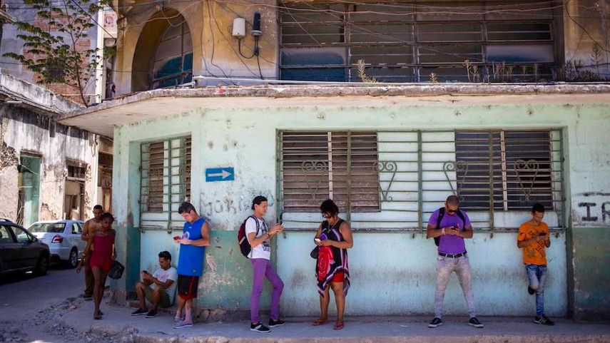 Varias personas en Cuba se conectan a internet en una calle.&nbsp;