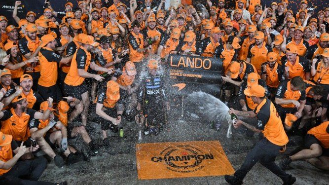 El piloto británico Lando Norris (C), campeón del mundo y tercer clasificado de McLaren, celebra con su equipo al final del Gran Premio de Fórmula 1 de Abu Dabi en el Circuito Yas Marina en Abu Dabi el 7 de diciembre de 2025. 