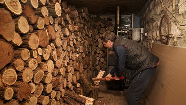 Tudor Popescu corta leña que utiliza para calentar su casa, en una leñera asociada a su casa en Chisinau, Moldavia, el sábado 15 de octubre de 2022.&nbsp;