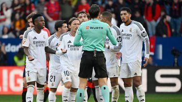 Los jugadores del Real Madrid protestan con el árbitro español Munuera Montero por la tarjeta roja mostrada al centrocampista inglés #05 del Real Madrid Jude Bellingham (R) durante el partido de fútbol de la liga española entre CA Osasuna y Real Madrid CF en el Estadio El Sadar en Pamplona el 15 de febrero de 2025.
