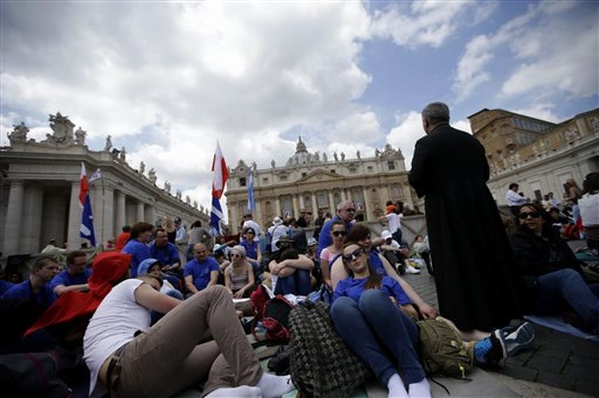 Un grupo de fieles polacos reza frente a la Basílica de San Pedro en el Vaticano el sábado 26 de abril de 2014. Peregrinos y fieles han comenzado a reunirse en Roma para asistir a la ceremonia de canonización de Juan XXIII y de Juan Pablo II que se cel