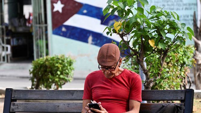 Un hombre usa su teléfono móvil en una calle de La Habana el 3 de junio de 2025. Las nuevas tarifas de internet móvil en Cuba, que entraron en vigor el 30 de mayo y dolarizaron parcialmente el servicio, han desatado una ola de descontento entre los usuarios.&nbsp;