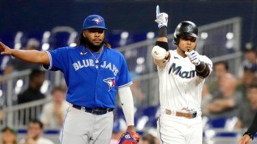 Luis Arráez, derecha, de los Marlins de Miami, reacciona después de batear un sencillo durante la primera entrada del juego de béisbol en contra de los Azulejos de Toronto, el lunes 19 de junio de 2023, en Miami. El primera base de Azulejos, Vladimir Guerrero Jr., izquierda, observa.&nbsp;