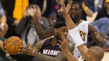 LeBron James (i) de los Heat de Miami intenta un pase contra David West (d) de los Pacers de Indiana, durante su partido de los Playoffs del Campeonato de la Conferencia Este de la NBA en el Bankers Life Fieldhouse.