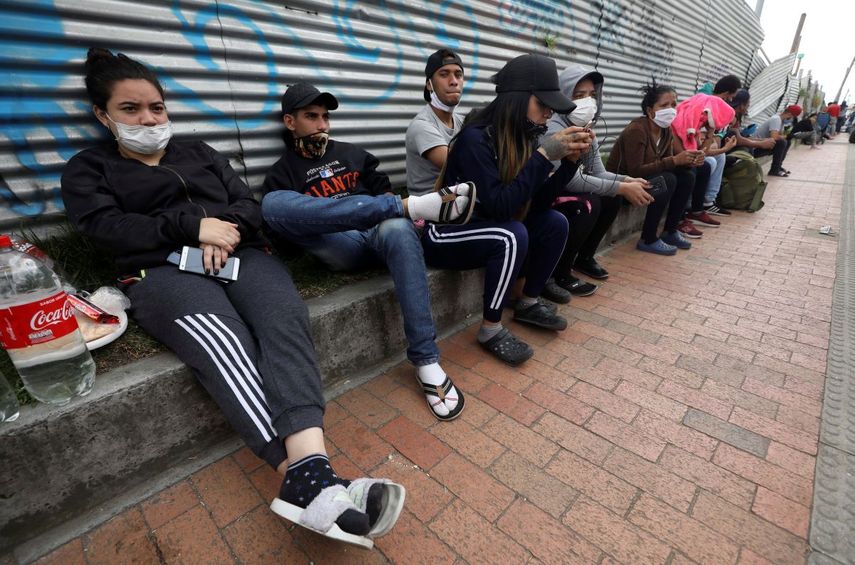 Migrantes venezolanos esperando a los autobuses que les llevarán a la frontera venezolana, en Bogotá, Colombia. Los migrantes quieren regresar a su país porque dicen que no pudieron encontrar trabajo por el cierre de negocios ordenado en Colombia para combatir el coronavirus. Imagen del 30 de abril de 2020,