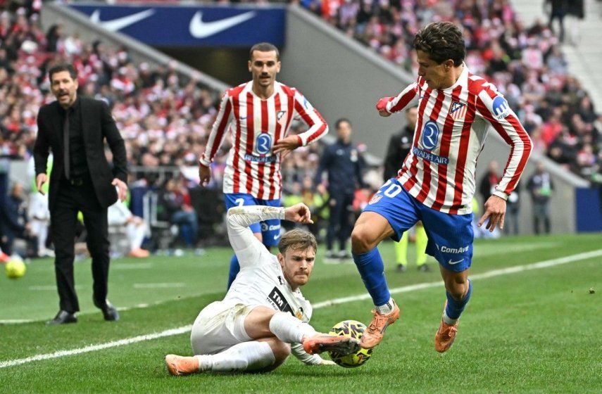 El delantero argentino del Atlético de Madrid # 20 Giuliano Simeone lucha por el balón con el delantero argentino # 15 Lucas Beltrán (abajo) durante el partido de fútbol de la liga española entre el Club Atlético de Madrid y el Valencia CF en el Estadio Metropolitano de Madrid el 13 de diciembre de 2025.&nbsp;