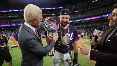 Cal Raleigh, número 29 de los Marineros de Seattle, recibe el cinturón de campeón de manos del luchador profesional Cody Rhodes tras ganar el Home Run Derby en el Truist Park el 14 de julio de 2025 en Atlanta, Georgia.