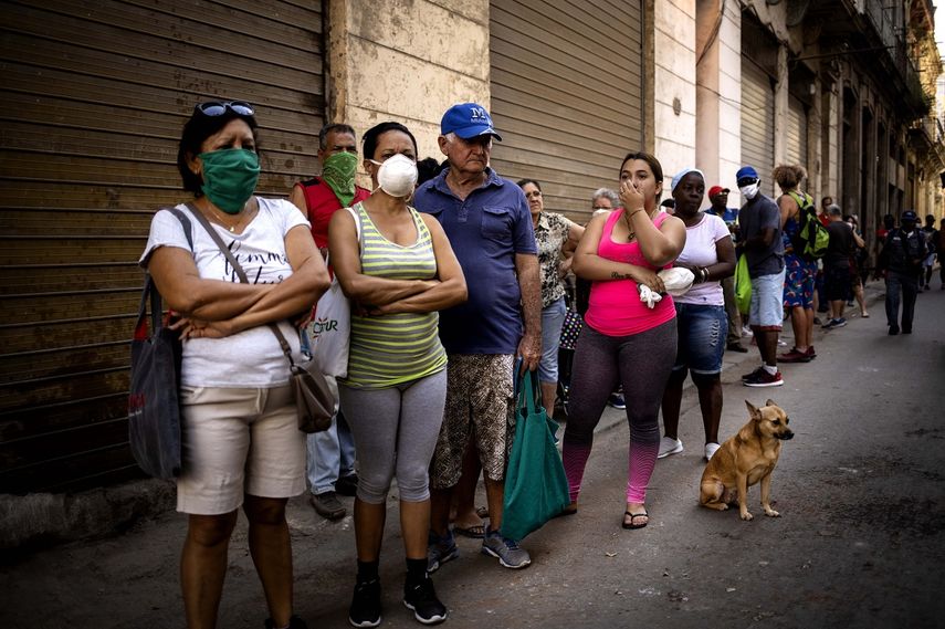 La gente hace fila para comprar alimentos, algunos usando mascarillas como precaución contra la propagación del nuevo coronavirus, en La Habana, Cuba, el martes 24 de marzo de 2020. 