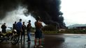 La gente mira el humo negro del incendio masivo en un depósito de combustible en una planta de refinación de petróleo de la estatal Petróleos de Venezuela (PDVSA) en Puerto La Cruz, estado de Anzoátegui, Venezuela  
