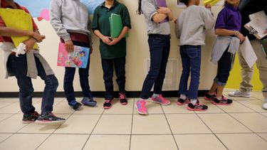 Niños y adolescentes inmigrantes hacen fila para una clase en un centro para menores en el Valle del Río Grande, en Texas.