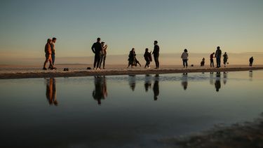 Curiosos caminan por el lecho seco del Lago Tuz en el centro de Turquía el 26 de octubre del 2021. Solo se ve una pequeña faja de agua poco profunda en el segundo lago más grande del país.