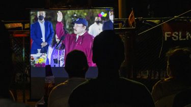 Gente mira la juramentación del presidente Daniel Ortega para un cuarto período consecutivo en una pantalla jugante en un barrio de Managua, Nicaragua, 10 de enero de 2022. 