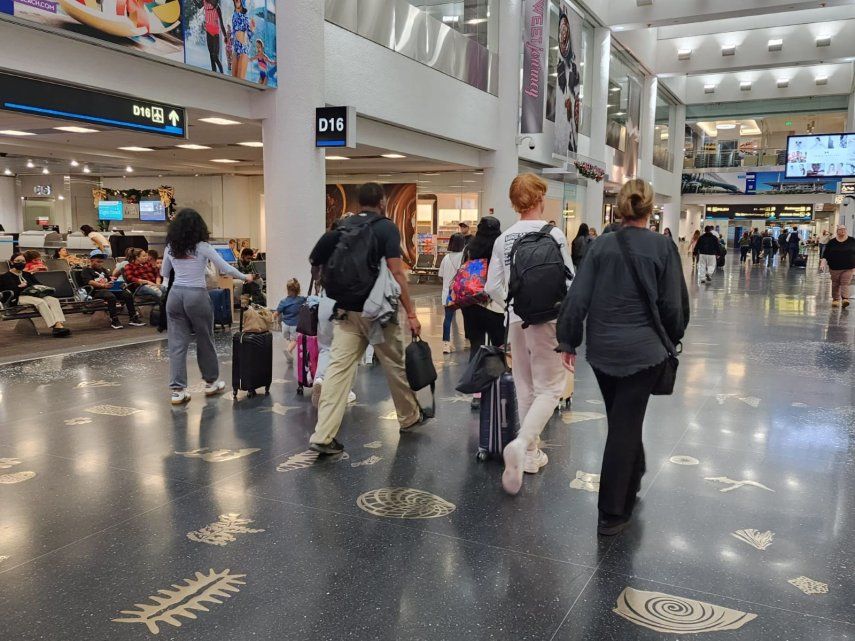 Viajeros en uno de los pasillos centrales del Aeropuerto Internacional de Miami.