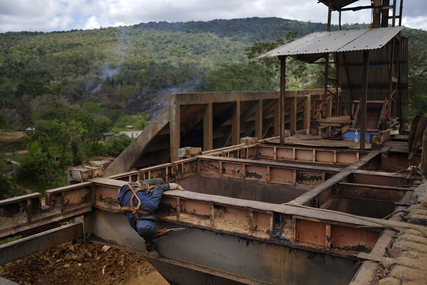 Un trabajador retira placas de hierro en una zona donde se efectúa minería subterránea de oro para reutilizarlas en molinos de piedra en El Callao, estado Bolívar, en Venezuela, el viernes 28 de abril de 2023. 