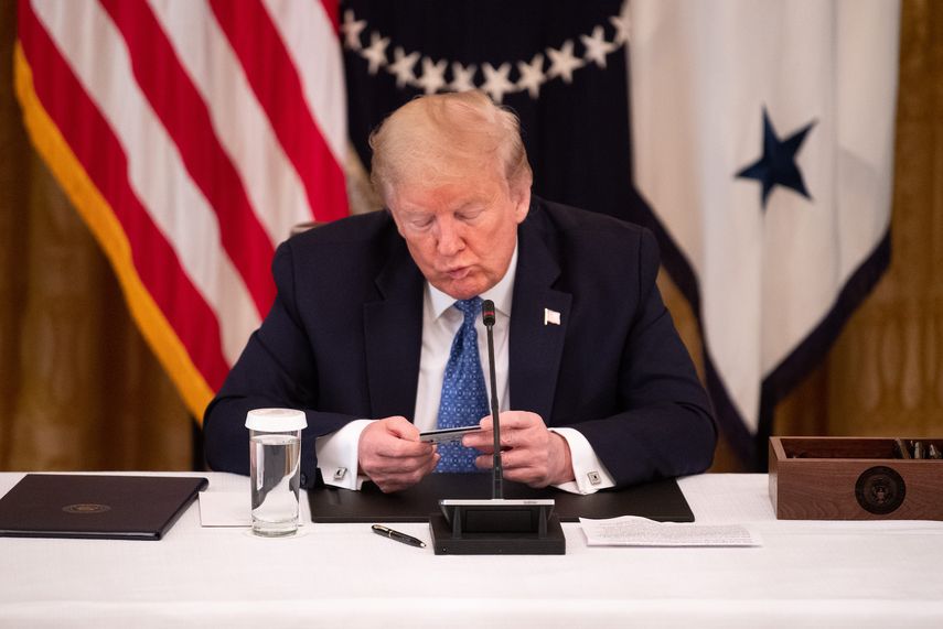 El presidente Donald Trump&nbsp;mira una tarjeta de d&eacute;bito usada para la distribuci&oacute;n de ayuda por el&nbsp;COVID-19,&nbsp;en la Casa Blanca,&nbsp;Washington, DC, el 19 de mayo de 2020.&nbsp;