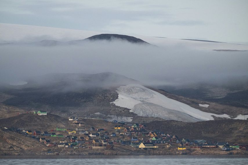 Esta fotografía tomada el 17 de agosto de 2023 muestra una vista general de Ittoqqortoormiit y su glaciar que proporciona agua potable a la aldea en el fiordo Scoresby, Groenlandia.