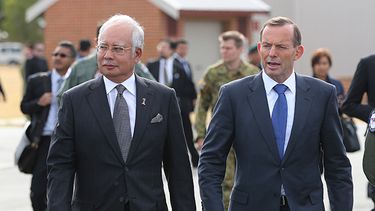 El primer ministro de Malasia, Najib Razak, a la izquierda, y el primer ministro australiano Tony Abbot se dirigen hacia miembros de tripulaciones que participan en la búsqueda de restos del avión perdido de Malasia Airlines en Perth, Australia. (AP)
