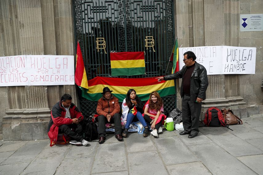 Manifestantes antigubernamentales se sientan afuera del palacio presidencial en La Paz, Bolivia, el domingo 10 de noviembre de 2019. El presidente Evo Morales est&aacute; pidiendo nuevas elecciones presidenciales luego que la Organizaci&oacute;n de los Estados Americanos (OEA) encontr&oacute; irregularidades al auditar las elecciones del 20 de octubre, en las que se impuso el mandatario en medio de denuncias de fraude.&nbsp;