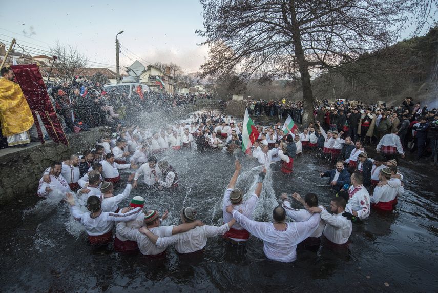 B&uacute;lgaros cantan y bailan en las heladas aguas del r&iacute;o Tundzha durante la festividad religiosa de la Epifan&iacute;a, en Kalofer, Bulgaria, el lunes 6 de enero de 2020.&nbsp;