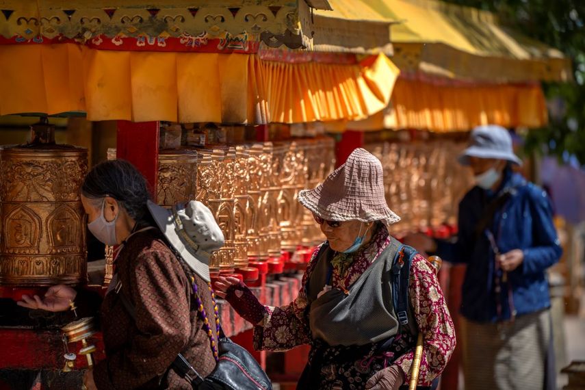 Fieles budistas hacen girar cilindros de oraciones antes de ingresar al Palacio Potala de Lahasa, en la Región Autónoma del Tibet en China.