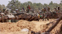 Las tropas israelíes trabajan en sus vehículos blindados en una posición cerca de la frontera de Israel con la Franja de Gaza el 18 de mayo de 2025.