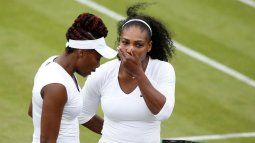 Las jugadoras estadounidenses Venus (izq) y Serena Williams hablan durante un partido de dobles en Wimbledon, el 30 de junio de 2016.