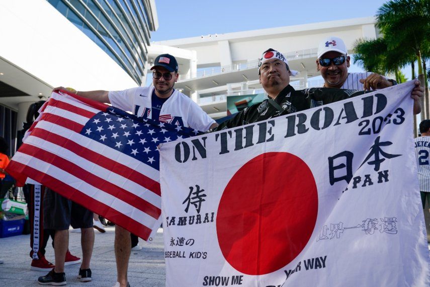 Shinjiro Suzuki sostiene una bandera de Japón previo a la final del Clásico Mundial de Béisbol entre el país asiático y Estados Unidos, el martes 21 de marzo de 2023, en Miami.