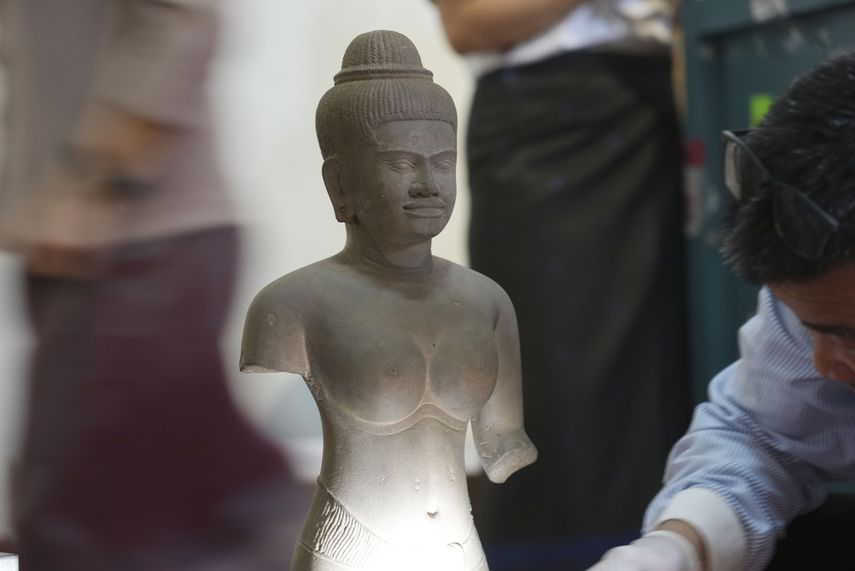Personal especializado prepara una estatua que regresó de Estados Unidos a Camboya, antes de una ceremonia oficial en el Museo Nacional de Camboya, el jueves 4 de julio de 2024, en Nom Pen, Camboya.