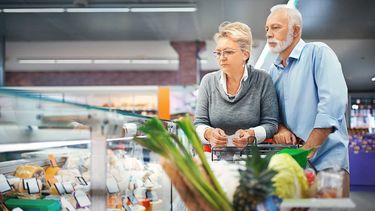 Una pareja observa los altos precios en los alimentos en un supermercado.
