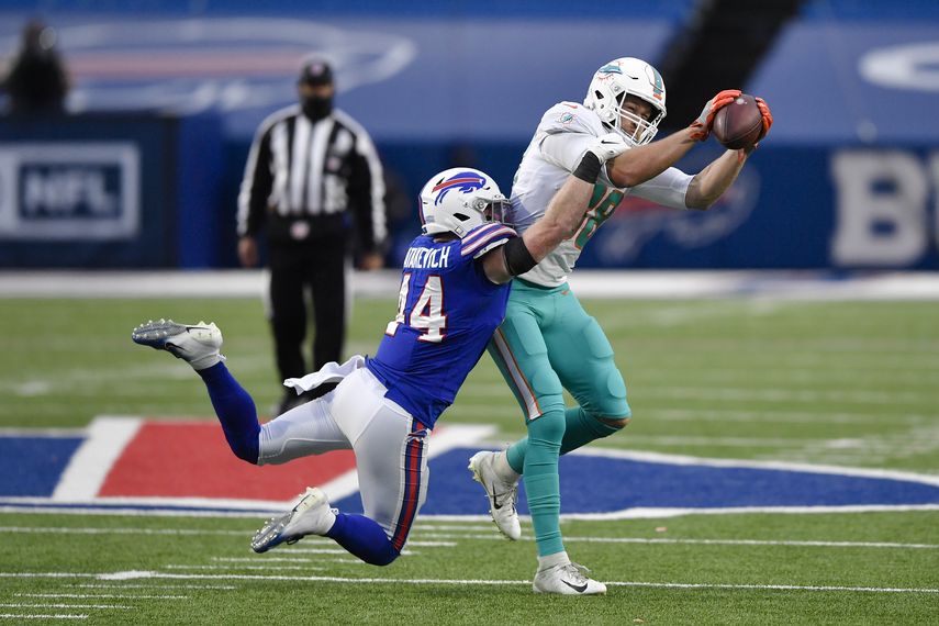 El ala cerrada de los Miami Dolphins Mike Gesicki (88) atrapa al apoyador interno Tyler Matakevich (44) de los Buffalo Bills en la segunda mitad de un juego de fútbol americano de la NFL, el domingo 3 de enero de 2021 en Orchard Park, Nueva York&nbsp;