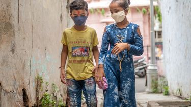 Dos niños con mascarilla en India.
