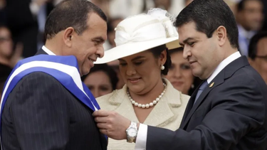 En esta foto del 27 de enero de 2010, Juan Orlando Hernandez, presidente del Congreso y actual mandatario, coloca la banda presidencial a Porfirio Lobo durante una ceremonia en Tegucigalpa, Honduras.